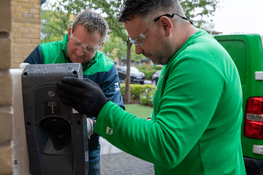 OVO engineers work outside on the EV charger