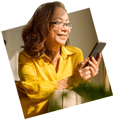 Happy woman resting on comfortable couch in bright living room and using smart phone.
