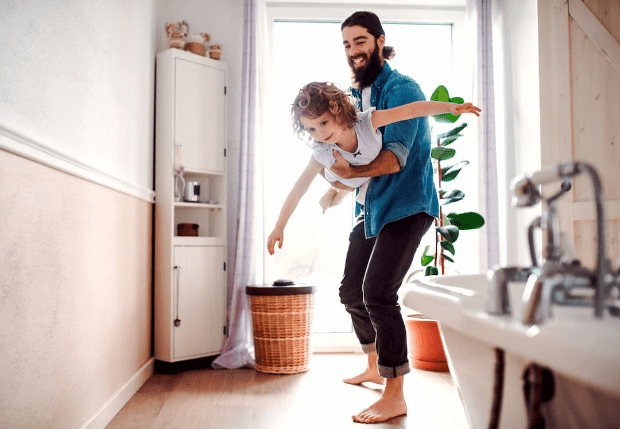 Man playing with child at home