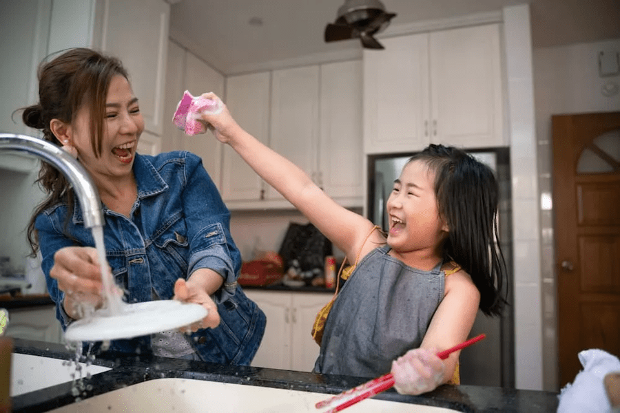 Mum and child washing the dishes together