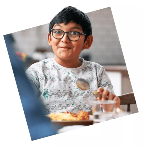 Boy eating dinner and smiling