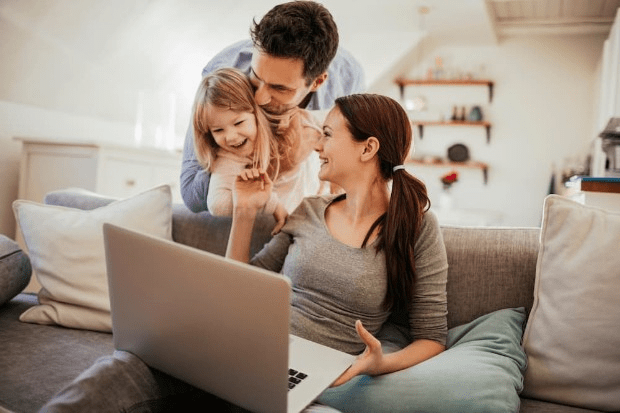 A family using a laptop to manage their smart home heating