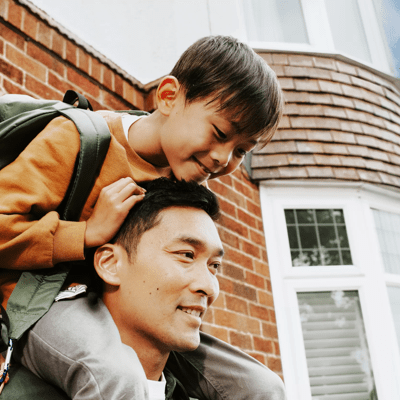 Man with child outside house