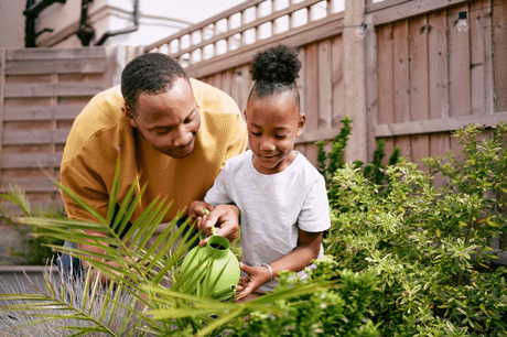 Father and child watering the garden plants