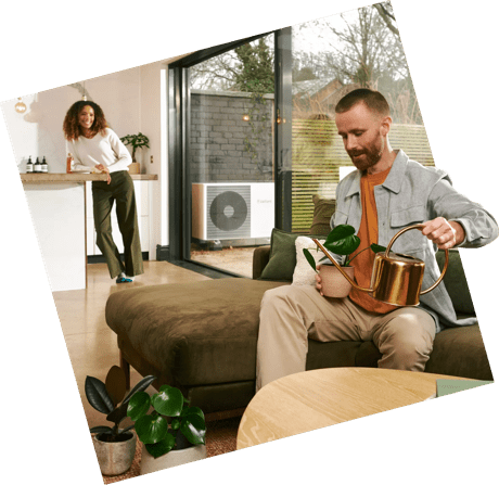 Man watering plant with heat pump in background
