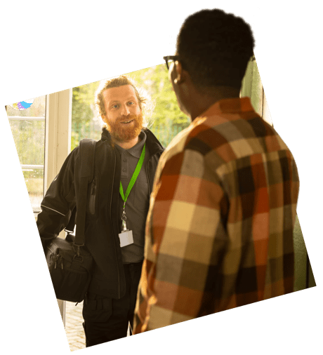 A customer greets a boiler engineer at the front door