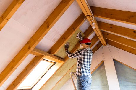 Person fitting roof insulation 
