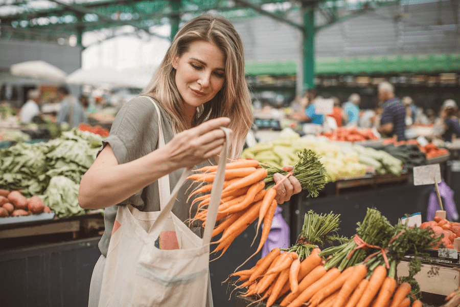 A woman shops for fruit and veg at the local market