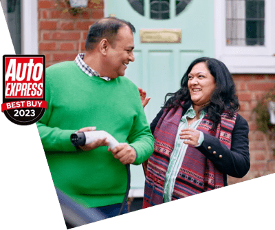 A man holding an EV charger outside a house, chatting to a woman, with a car in the foreground