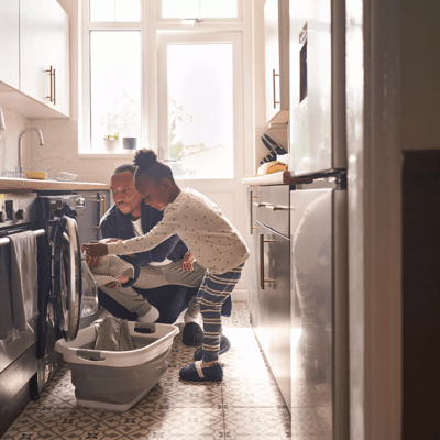 Family loading washing machine in home