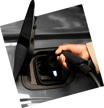 Hand plugging an EV charger into a car's charging port.