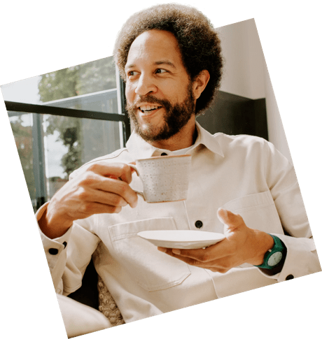 Man drinking a cup of tea smiling