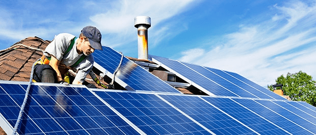 man fitting solar panels to roof