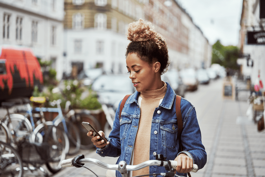 young black woman using mobile phone on the street