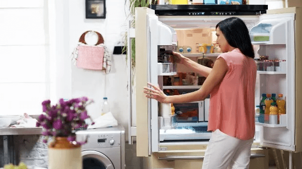 A woman looking for food in the fridge