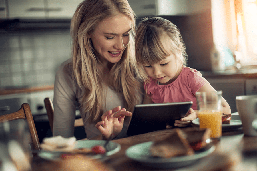 Mother and daughter using a tablet to control the temperature in their home
