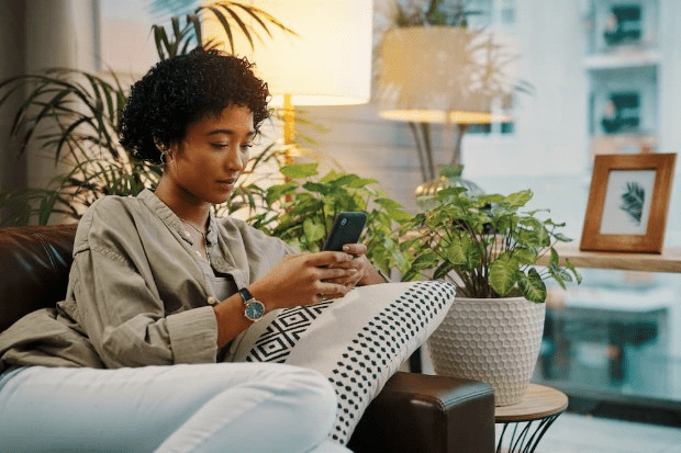 A woman using her smart phone at home