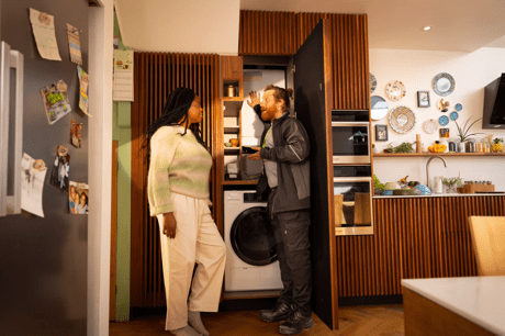 A woman talking to a boiler engineer in her kitchen 