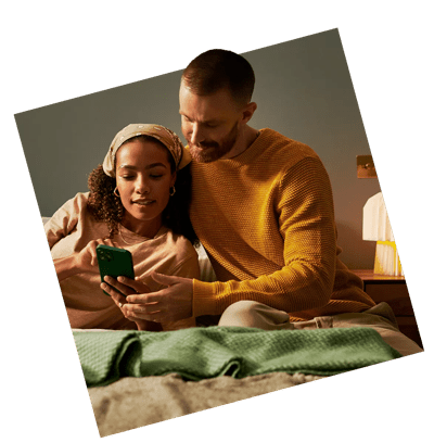 Couple in bedroom looking at phone