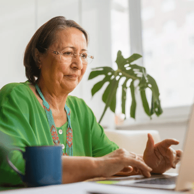 Woman sat at a desk using her computer at home