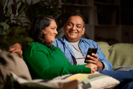 A couple laughing on the sofa