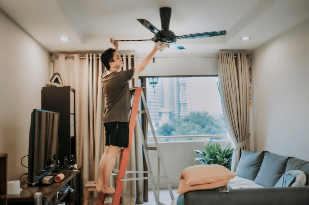 Man installing a ceiling fan at home