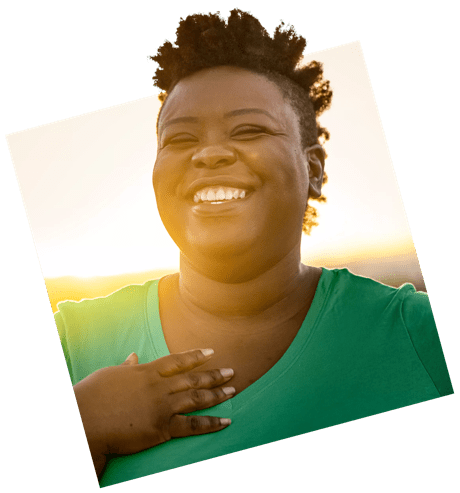 Black woman smiles with sun behind her