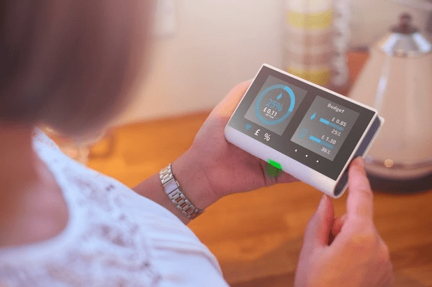 Woman using an energy monitor at home